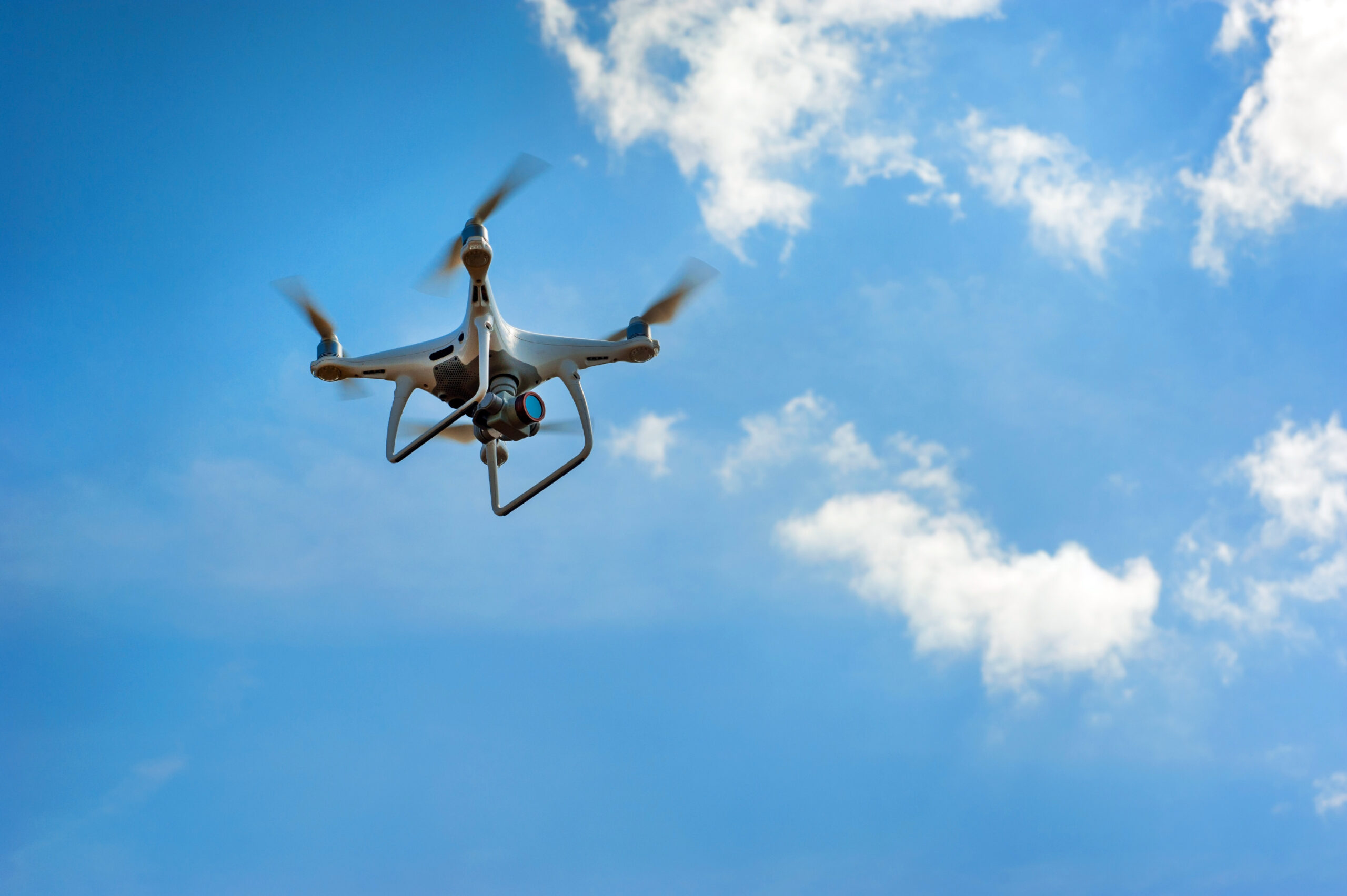 Drone inspect farmland, fly at sky with clouds. Concept of technology in the farm.